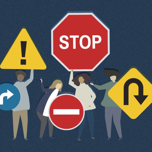 Pessoas seguram placas de trânsito com sinais de risco