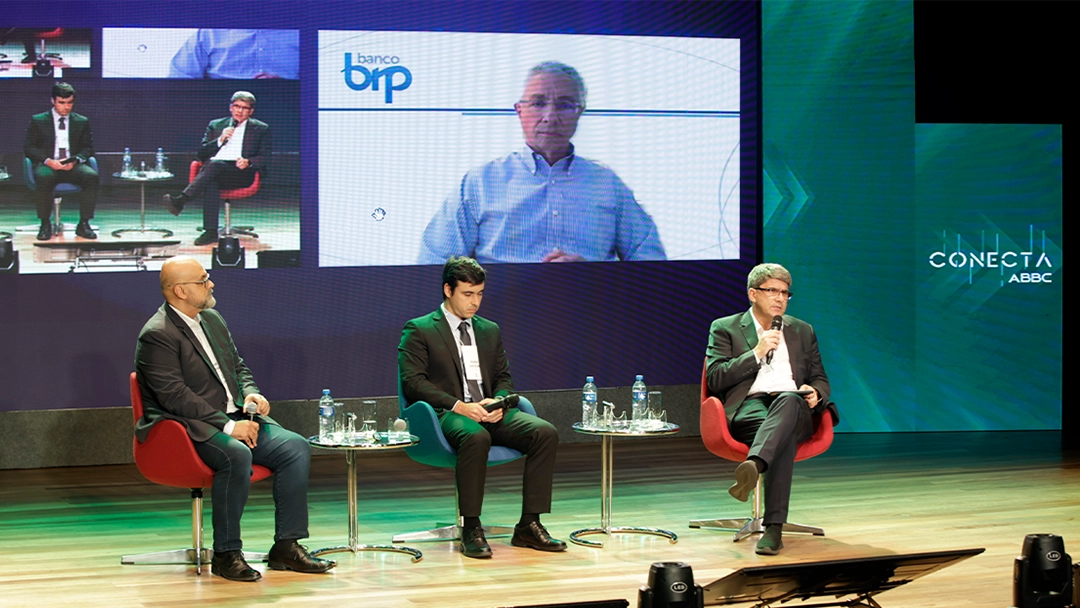 Da esquerda para a direita, Fábio Araújo, do BC, Pedro Castelar, da CVM, Raul Moreira, da ABBC e na tela Nelson Rocha, da ABBC. Créditos: Vinicius Stasolla
